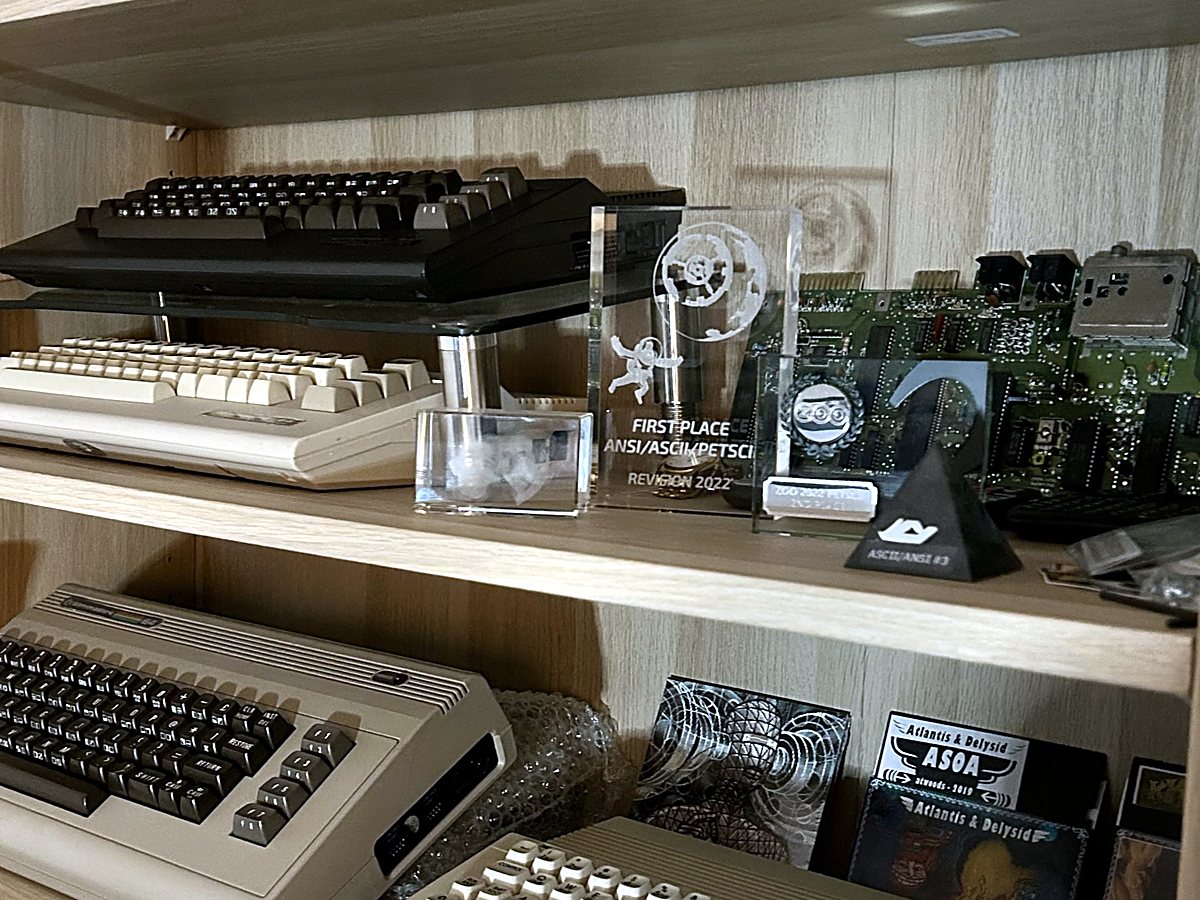 The C64 collection, plus compo trophies: #1 PETSCII and ANSI at Revision 2022, #1 PETSCII at X 2024
