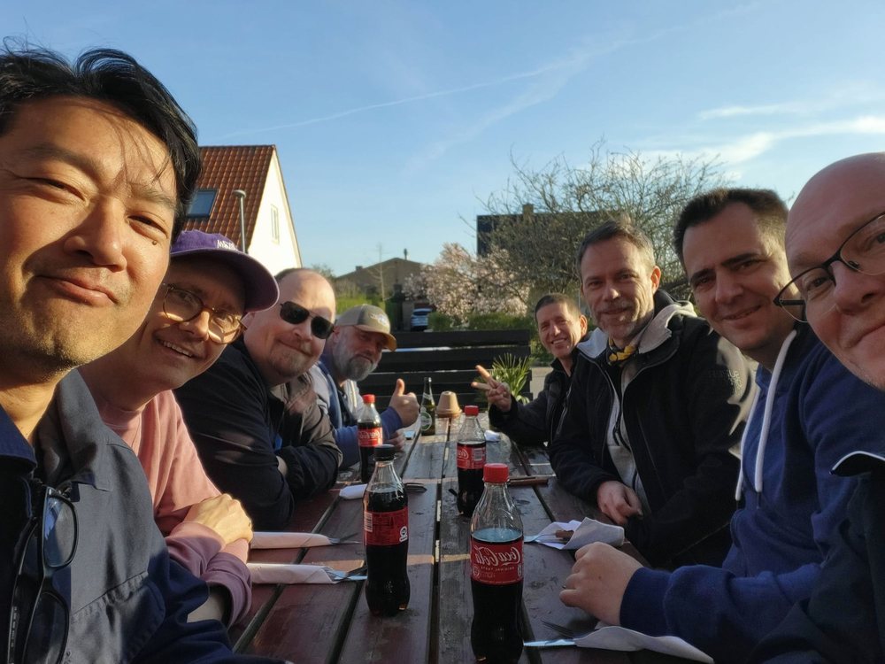 The crew at a long table outside the local pizzeria