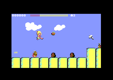 C64 Wonder Boy round 4-2: the boy leaps over snails on rows of yellow pillars under a blue sky