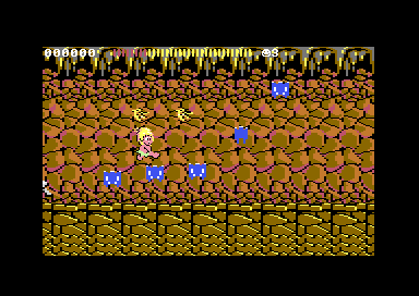 C64 Wonder Boy round 2-2: the boy jumps through a brown cave as six blue bats swoop around him